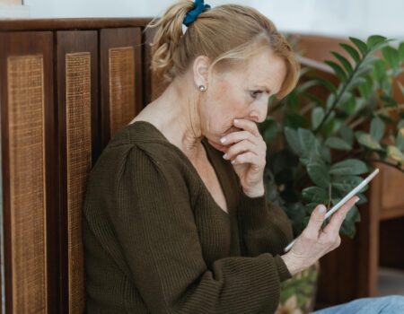 Person reading news headlines and feeling concerned about finances during uncertain times – accountant in Tasman