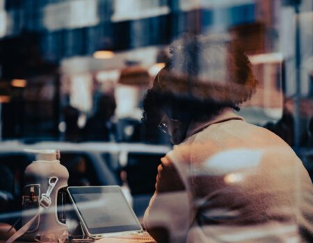Woman sitting at a desk in quiet reflection, representing the emotional side of making big business decisions — insight from your Accountant in Motueka